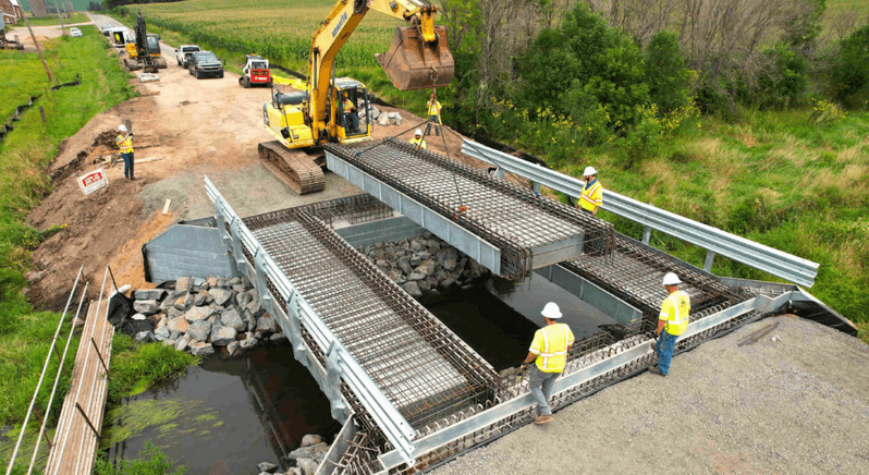 Construction workers installing an InQuik modular bridge, showcasing the company's innovative technology in action.