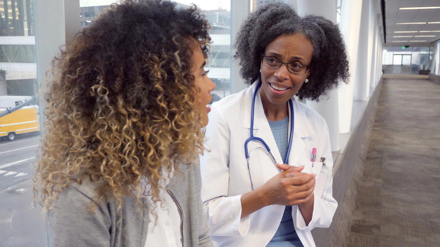 Mature female doctor visits with patient