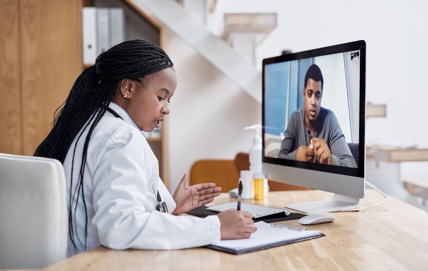 Taking Notes during Her Virtual Consult. Shot of a Young Doctor