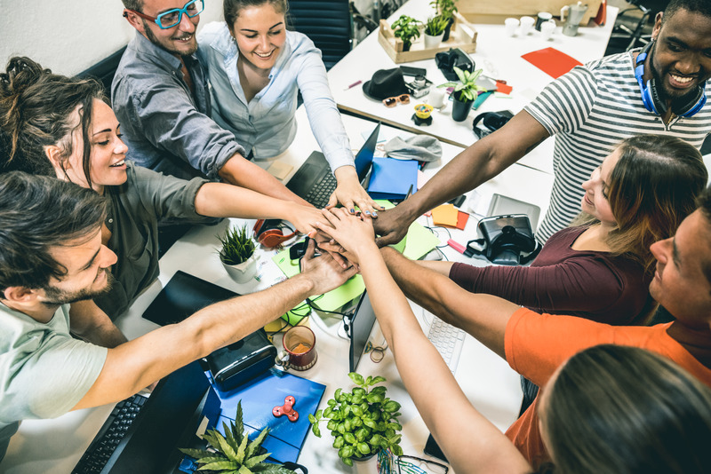 A diverse team putting their hands together, symbolizing unity.
